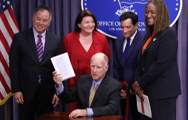 Jerry Brown is showing holding up California's state budget on June 27, 2018. This is his final time as governor signing a budget.