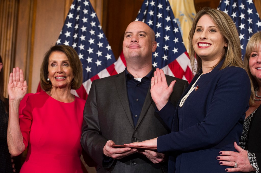 House Speaker Nancy Pelosi swears in Rep. Katie Hill, with Hill's now-estranged husband, Kenny Heslep, during the opening session of the 116th Congress in January. AP Photo/Cliff Owen