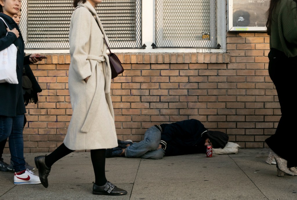 A man sleeps on Valencia street in the mission district of San Francisco. Photo by Anne Wernikoff for CalMatters