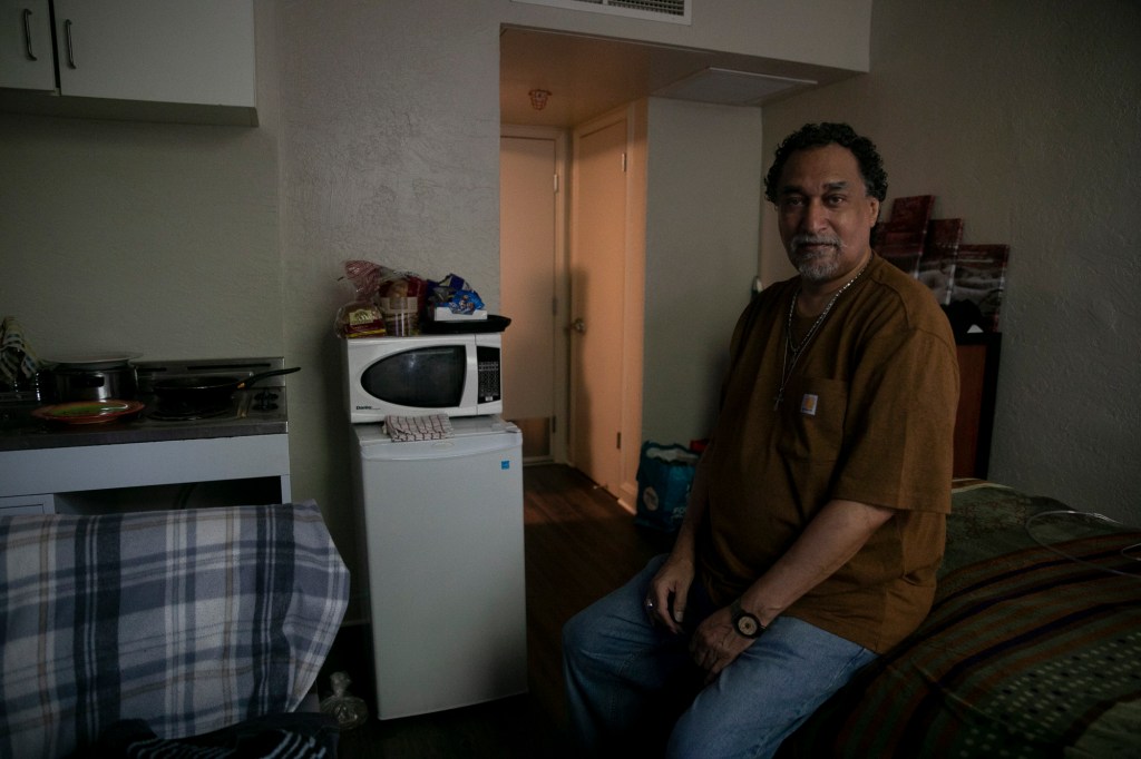 Salvador Bradford in his studio at Hotel Berry. Bradford has been living in the one-room unit for 8 months and spends most of his time watching movies and keeping his room tidy. Photo by Anne Wernikoff for CalMatters