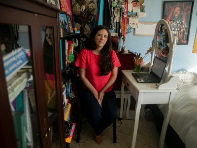 Sarah Rivas, 27, sits for a portrait at her desk where she teaches high school history from her childhood bedroom at her parents’ home in Elk Grove, Calif., on Oct. 13, 2020. Rivas, who moved back in with her parents during lockdown and subsequently gave up her apartment in Silicon Valley, worries that she would be unable to afford a new apartment if she were to return to teaching on campus. Photo by Anne Wernikoff for CalMatters