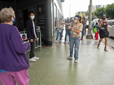 A poll working ushers a voter into the Wiltern Theater in Los Angeles' Korea Town neighborhood on Oct. 24, 2020. Photo by Tash Kimmell for CalMatters.