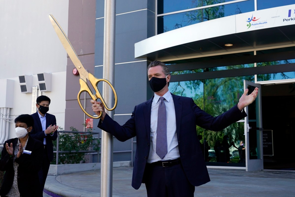 Gov. Gavin Newsom participates in a ribbon cutting ceremony at a new $120 million, 134,000 sq. foot coronavirus testing facility Oct. 30, 2020, in Valencia. The state is working with corporate partner PerkinElmer to run the lab which will enable the state to process an additional 150,000 COVID-19 tests per day. Photo by Marcio Jose Sanchez, AP Photo/Pool