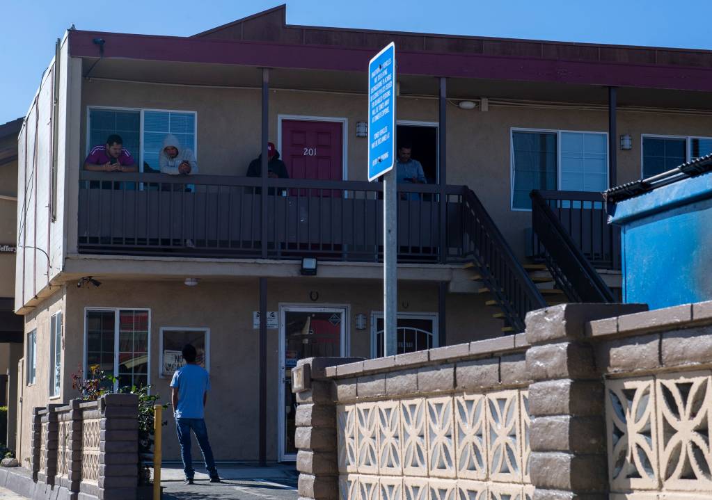 A few H2A workers hanging out n the second floor of the Budget Inn Motel in Salinas talk to a person standing just right outside their room on April 2, 2020. Photo by David Rodriguez, The Salinas Californian