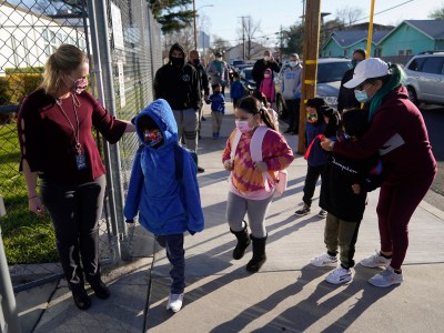 Parents drop off their childern as Assistant Principal Janette Van Gelderen, left, welcomes students at Newhall Elementary in Santa Clarita on Feb. 25, 2021. Photo by Marcio Jose Sanchez, AP Photo