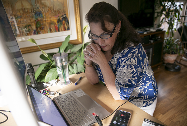 Alyssa Jenkins has a phone call with a person in search of a vaccine while using MyTurn at her Pacifica home on April 19, 2021. Jenkins has made appointments for more than 400 people since February. Photo by Anne Wernikoff, CalMatters