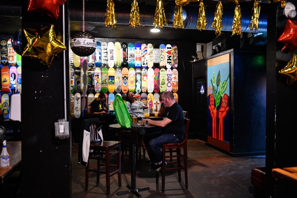 Maskless customers sit for drinks inside The Good Bar in Long Beach, on June 15, 2021. Starting Tuesday, California will not have rules regarding social distancing and capacity limits inside restaurants, bars, gyms or stadiums. Mandates for masks have also been lifted by the state. Some businesses are not requiring customers to wear masks now. Pablo Unzueta for CalMatters