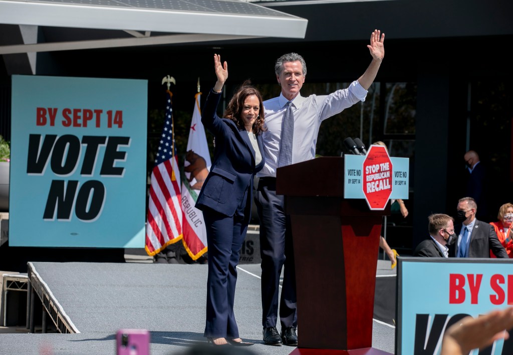 Vice President Kamala Harris and Gov. Gavin Newsom wave to the crowd during a campaign rally at the IBEW-NECA training center in San Leandro on Sept. 8, 2021. Newsom faces the recall election next week. Photo by Anne Wernikoff, CalMatters