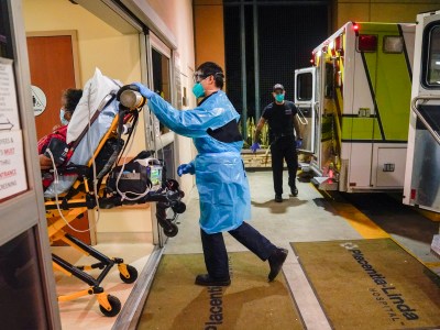Emergency medical technician Thomas Hoang, 29, of Emergency Ambulance Service, pushes a gurney into an emergency room to drop off a COVID-19 patient in Placentia on Friday, Jan. 8, 2021. Photo by Jae C. Hong, AP Photo