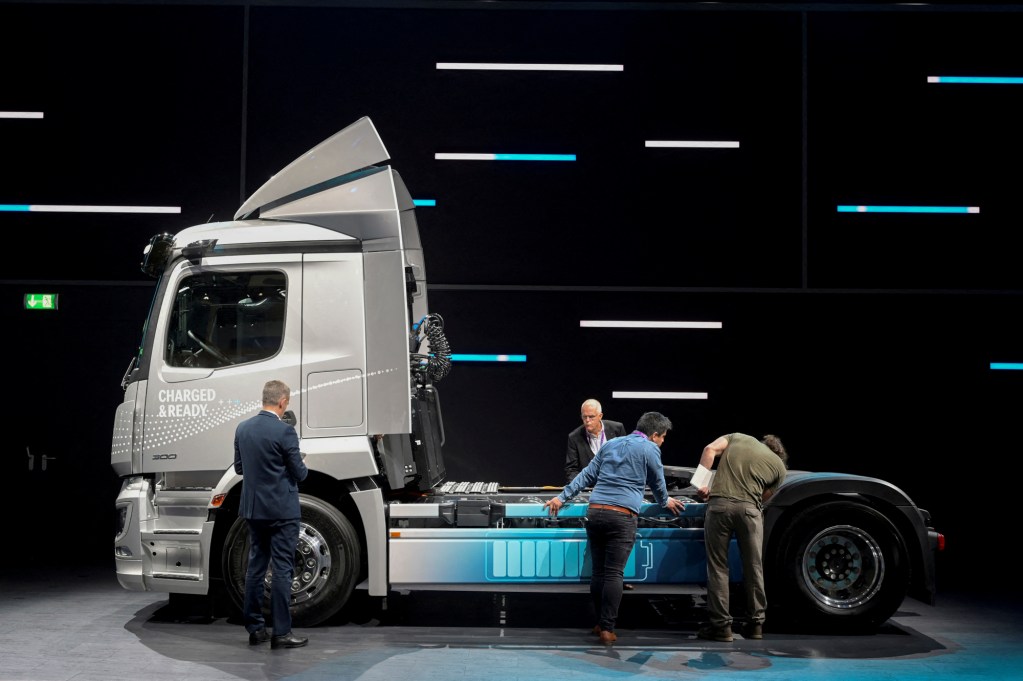 Members of the media stand beside an electric Actros truck at the booth of German truckmaker Daimler Truck at the IAA Transportation fair in Hanover, Germany, on September 19, 2022. Photo by Fabian Bimmer, Reuters