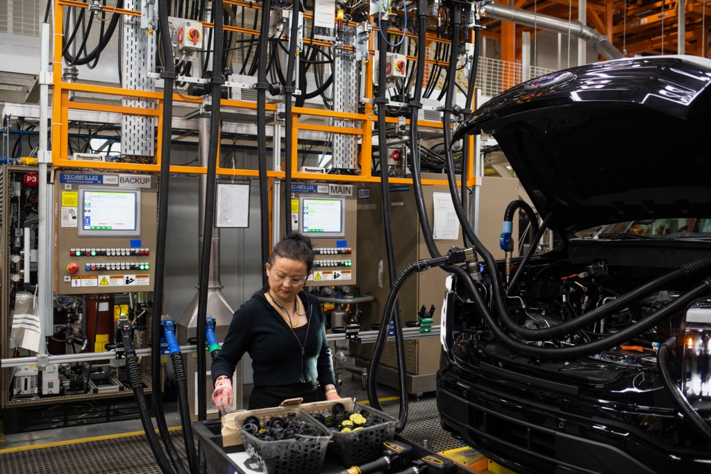 A worker tends to an electric Ford F-150 vehicle on the assembly line at the Ford River Rouge complex in Dearborn, Michigan on April 4, 2023. Photo by Emily Elconin for CalMatters