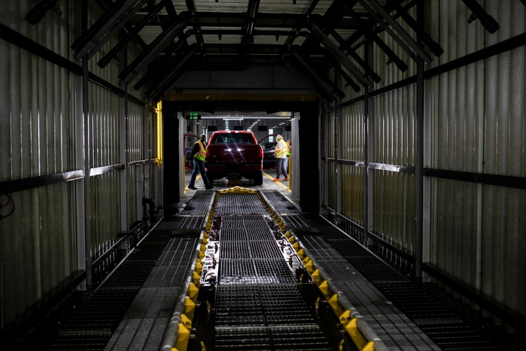 An electric Ford F-150 Lightning vehicle goes through a water test after assembly at the Ford River Rouge complex in Dearborn, Michigan on April 4, 2023. Photo by Emily Elconin for CalMatters