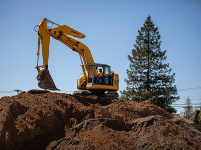 An excavator operates at the Quito Village Development Project in Saratoga on Apr. 13, 2023. Photo by Martin do Nascimento, CalMatters