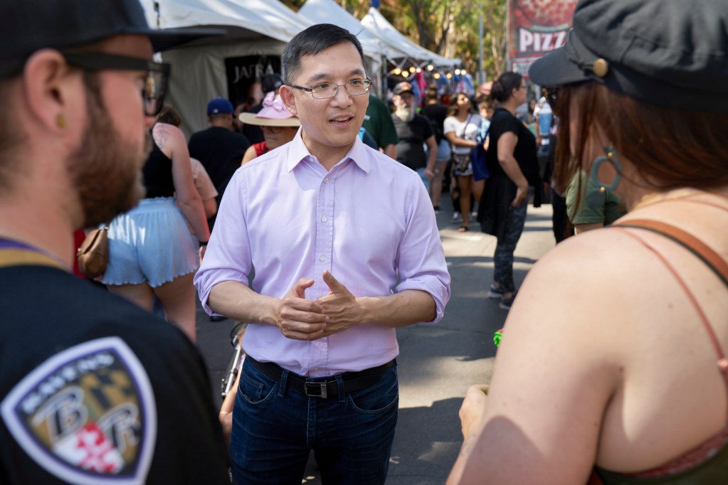 Democrat Jay Chen speaks with prospective voters at the 62nd Garden Grove Strawberry Festival while canvassing ahead of the Tuesday primary for the new 45th Congressional District on May 29, 2022. Photo by Bing Guan for CalMatters