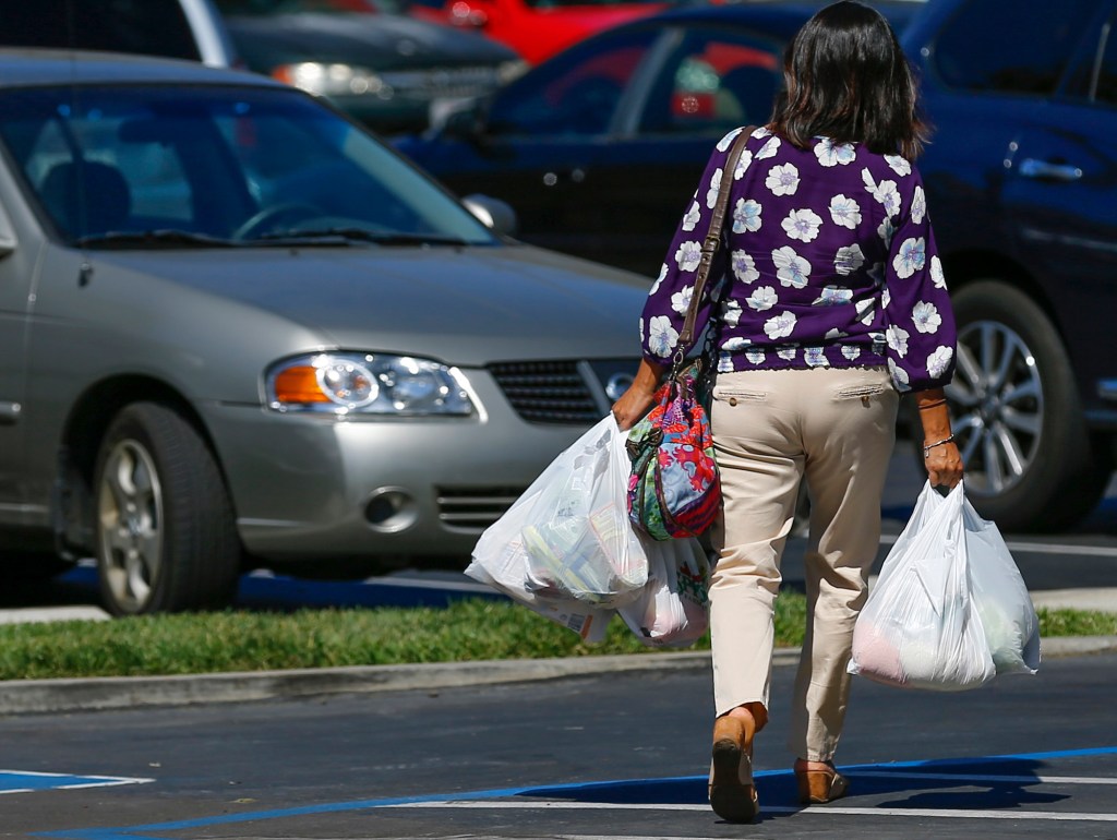 A shopper carries her groceries to her car in plastic bags after shopping at a Sprouts grocery store in San Diego on September 30, 2014. Photo by Mike Blake, Reuters