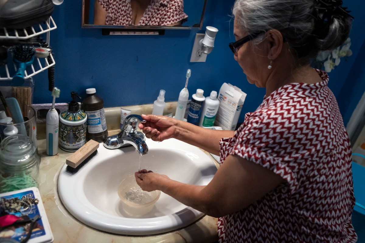 María Dolores Díaz keeps a bowl in the sink while she washes her hands to save water on Aug. 8, 2022. Photo by Larry Valenzuela, CalMatters/CatchLight Local