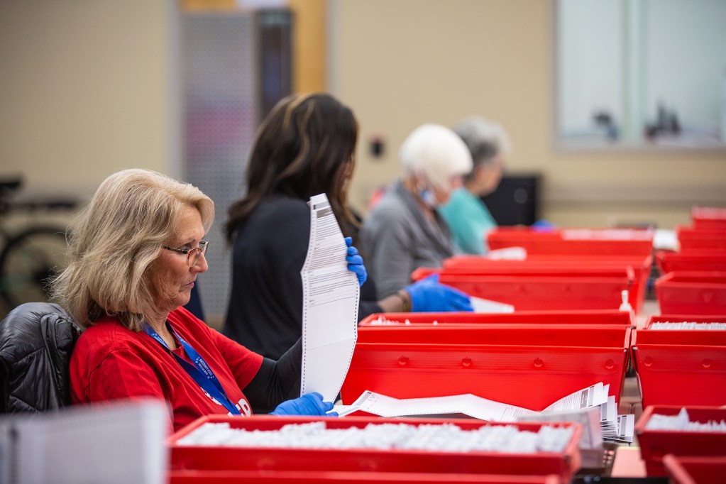 Election workers sort ballots at the Sacramento County voter registration and elections office in Sacramento on Nov. 8, 2022. Photo by Rahul Lal, CalMatters