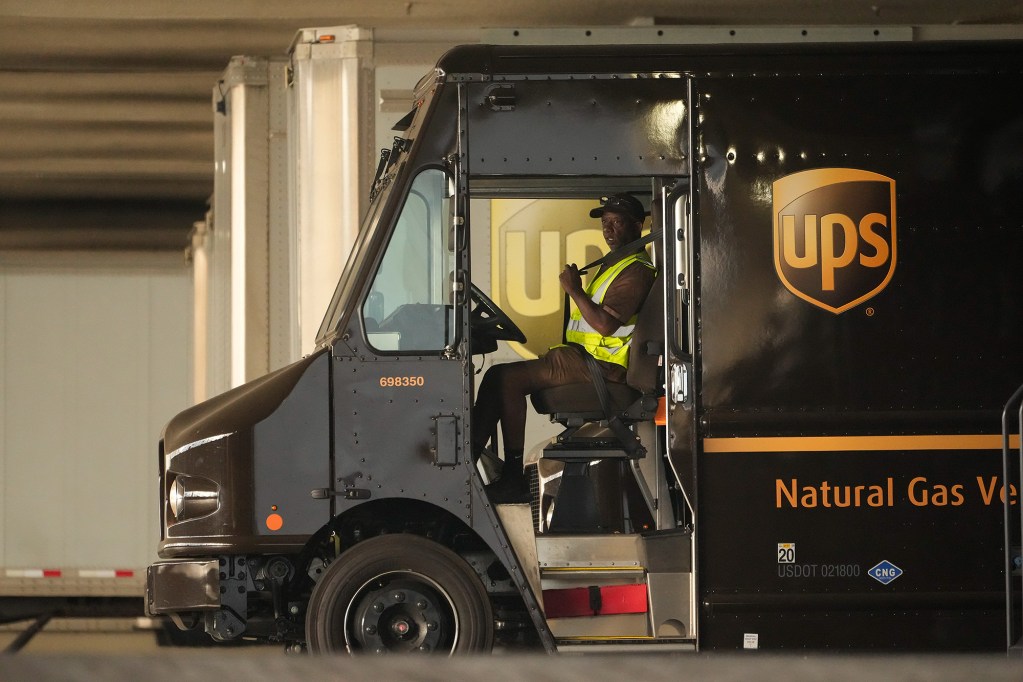 A UPS driver puts his seat belt on before driving off as UPS workers hold a rally in Los Angeles on July 19, 2023. Photo by Damian Dovarganes, AP Photo