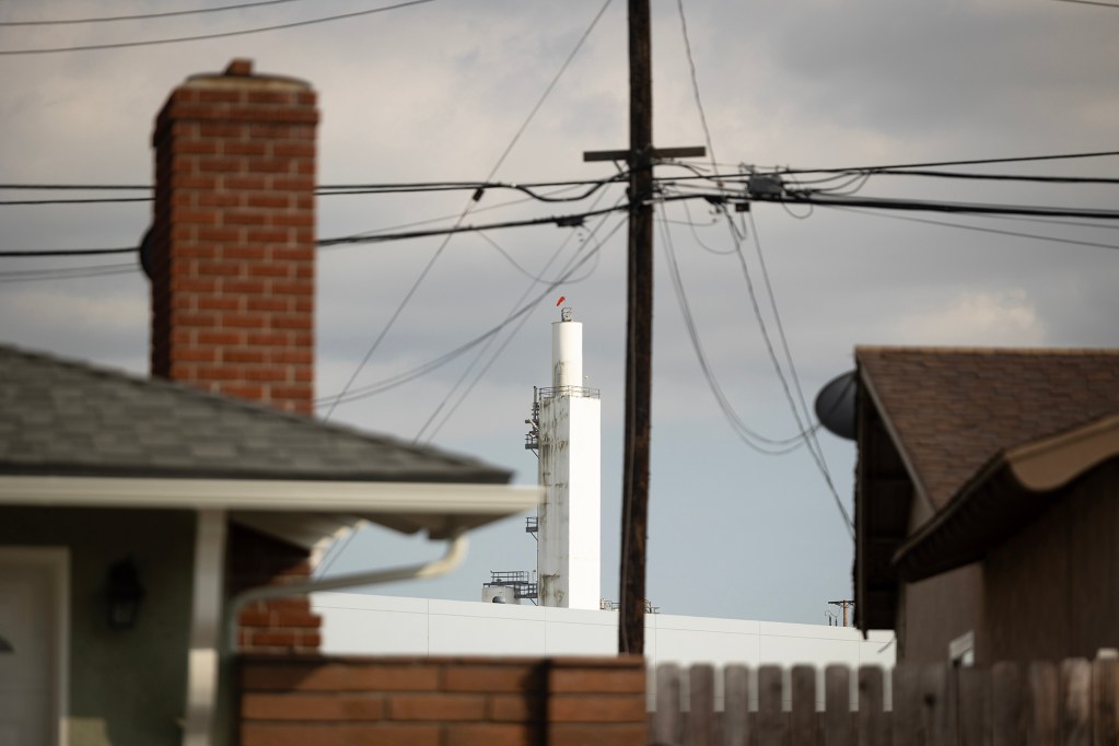 A tower from an Airgas plant, a supplier of gases and welding equipment, is visible from a residential neighborhood in Los Nietos on June 7, 2023. Part of the community abuts an industrial park. Photo by Miguel Gutierrez Jr., CalMatters