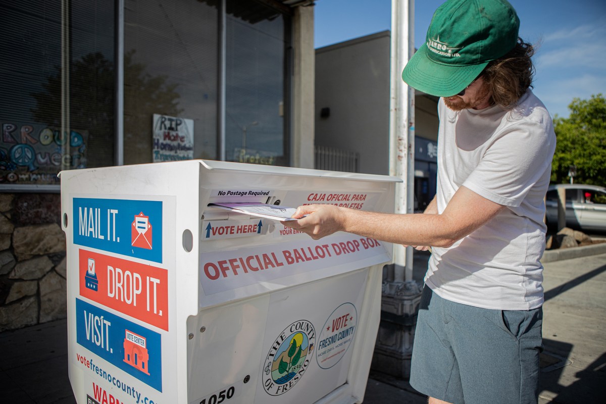 A voter drops off a ballot inside an official ballot drop box located in Tower District in central Fresno on June 7, 2022.