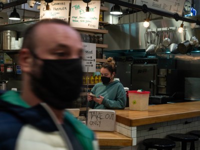 Katelyn Woolcott, a server at Wexler's Deli inside the Grand Central Market in Los Angeles, prepares the take-out orders on Jan. 19, 2022.
